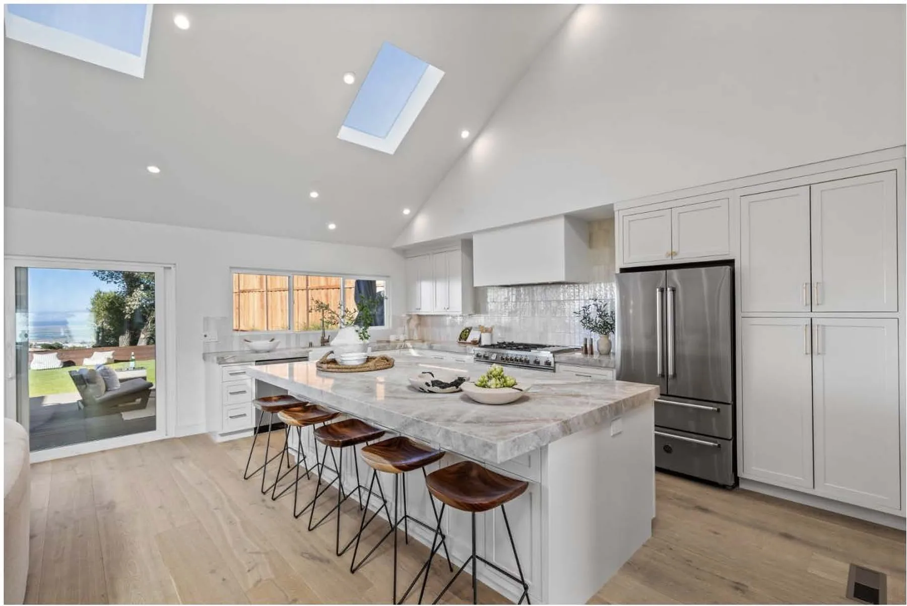Bright remodeled kitchen with oak cabinetry and a stone island