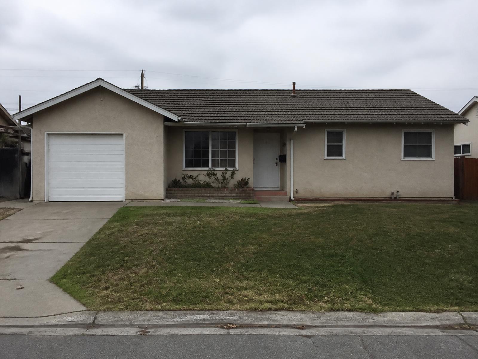Before: the original single-story house with dated stucco