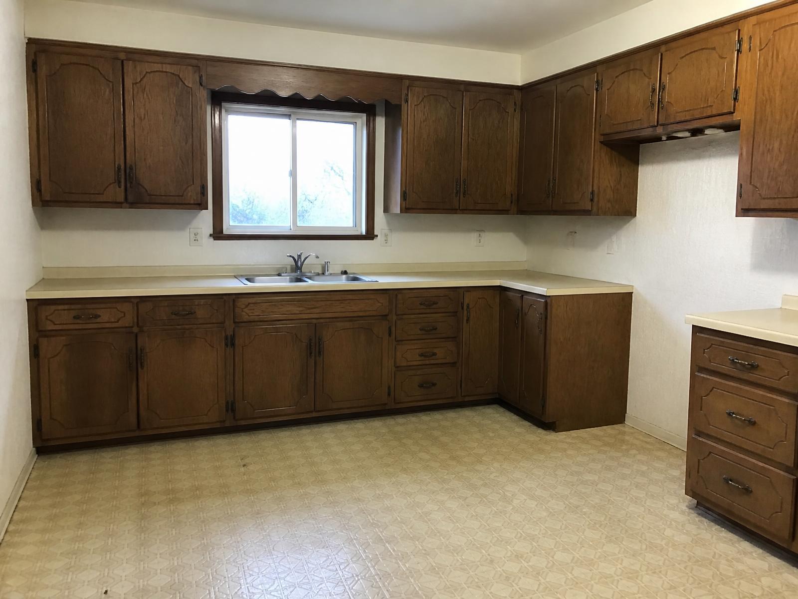 Before: dated kitchen with dark oak cabinets and laminate counters